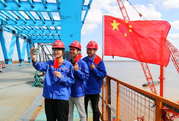中铁大桥局沪渝蓉高铁崇启公铁长江大桥员工和国旗同框。2